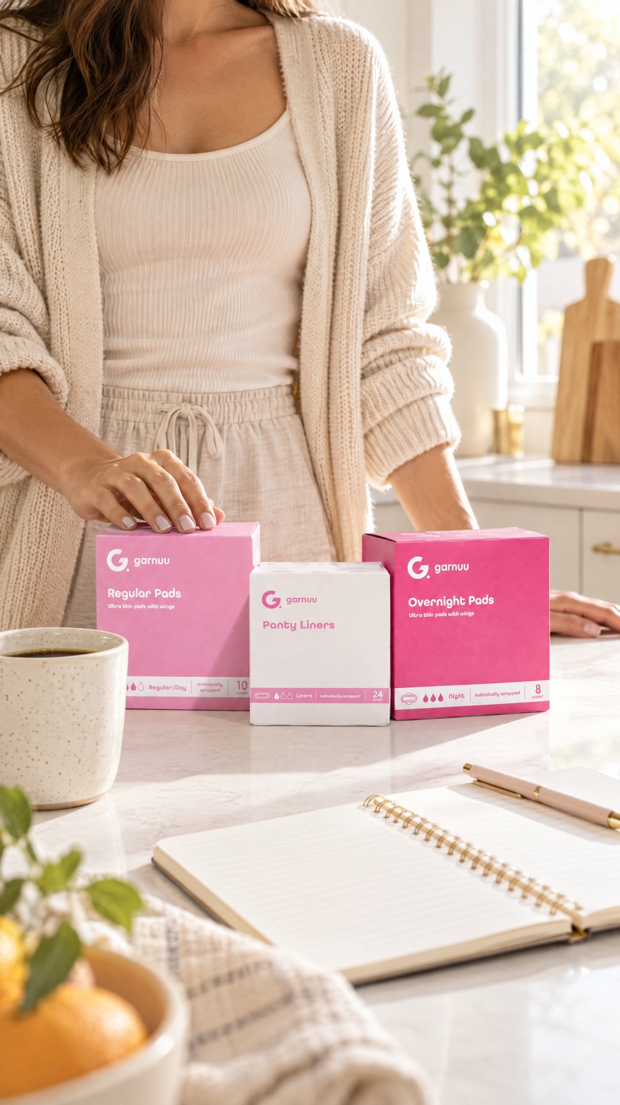 A woman at a kitchen island with a Garnuu Regular Pads box beside her coffee