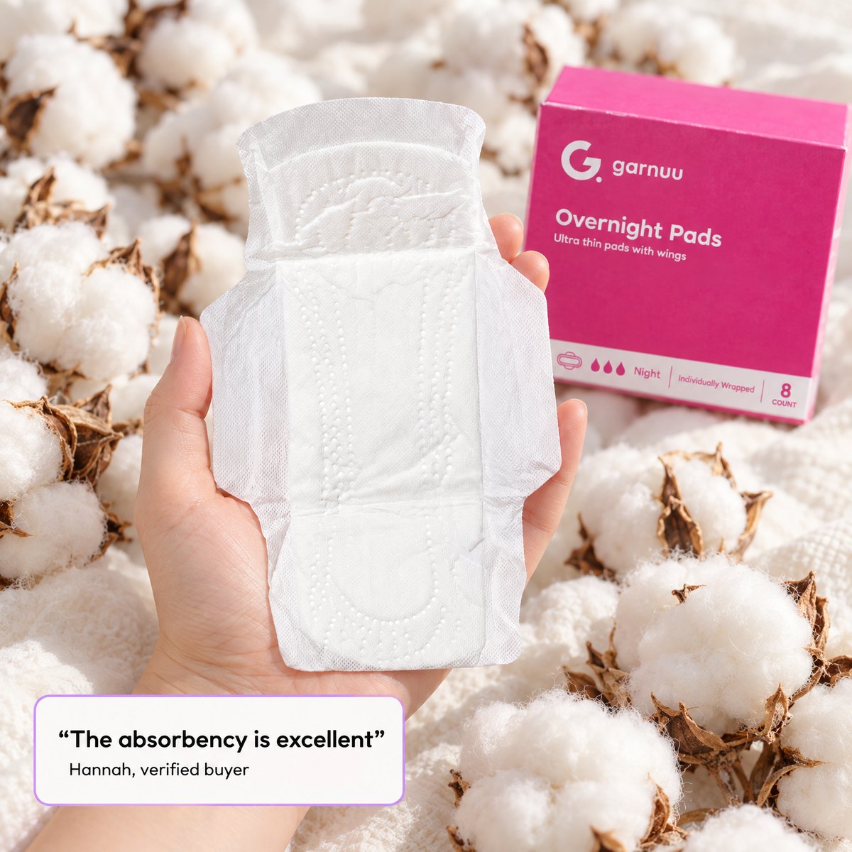 A hand holding one wrapped Garnuu pad over raw cotton, with a verified buyer's line: the absorbency is excellent